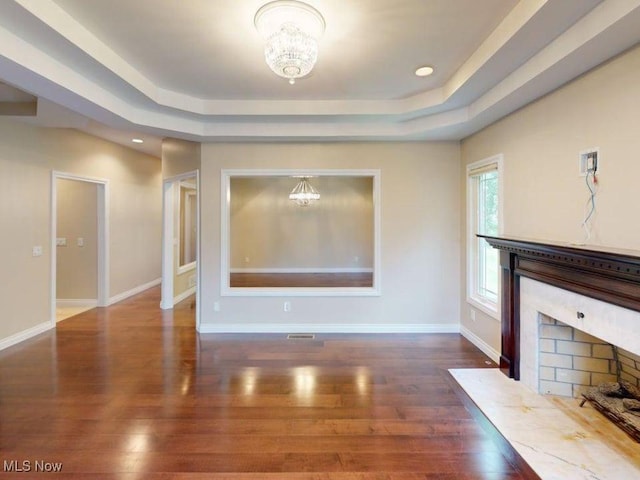 2474 Ginger Wren Rd, Pepper Pike, OH 44124 - unfurnished living room with a chandelier, a raised ceiling, a premium fireplace, wood finished floors, and recessed lighting