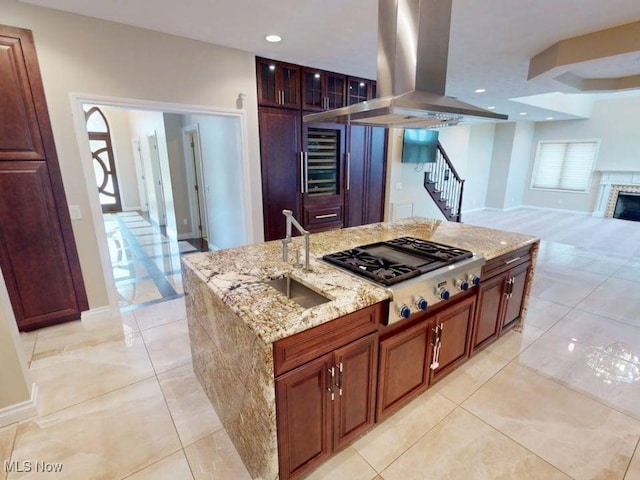 2474 Ginger Wren Rd, Pepper Pike, OH 44124 - kitchen featuring island range hood, stainless steel gas stovetop, beverage cooler, light stone countertops, and a kitchen island