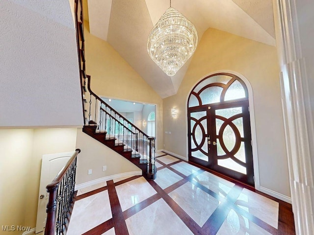2474 Ginger Wren Rd, Pepper Pike, OH 44124 - entrance foyer with french doors, inlaid floor details, a high ceiling, a chandelier, and stairs