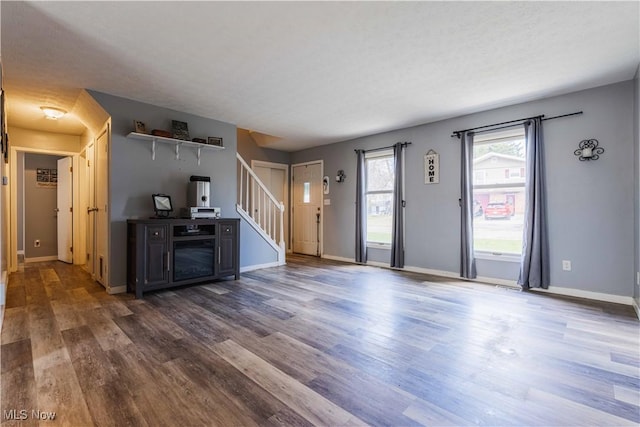 1582 Hilda Ave, Lakemore, OH 44250 - unfurnished living room featuring dark wood-type flooring and stairway