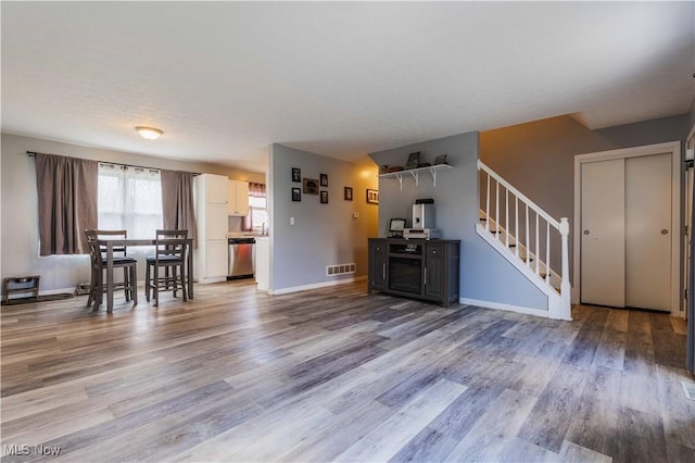 1582 Hilda Ave, Lakemore, OH 44250 - living area with stairway and light wood-style floors