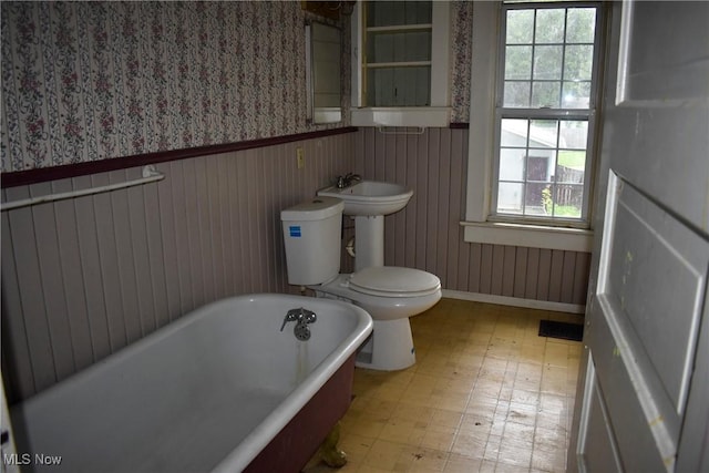 664 N Ellsworth Ave, Salem, OH 44460 - bathroom with wallpapered walls, a freestanding bath, tile patterned floors, and a wainscoted wall