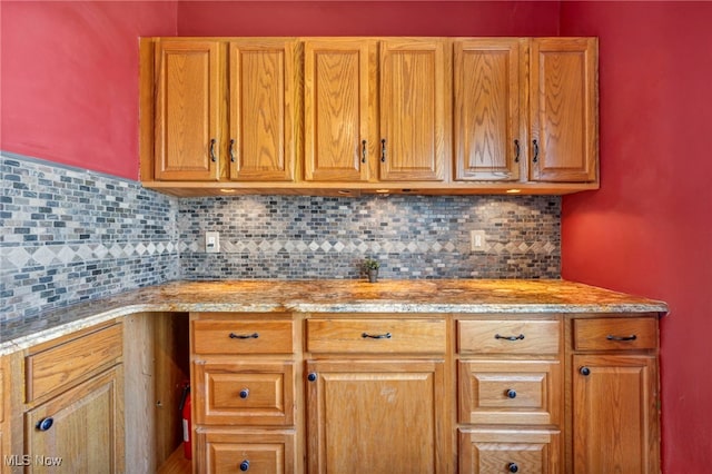 3303 Tuxedo Ave, Parma, OH 44134 - kitchen with backsplash, light stone countertops, and brown cabinets