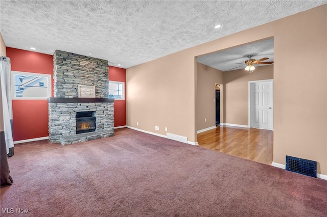 3303 Tuxedo Ave, Parma, OH 44134 - unfurnished living room featuring plenty of natural light, carpet flooring, a textured ceiling, ceiling fan, and a fireplace