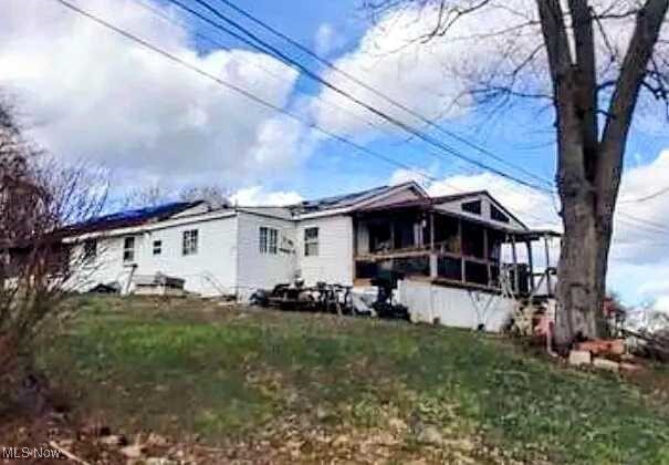73 Comer St, Parkersburg, WV 26101 - view of front of home featuring a sunroom and a front yard