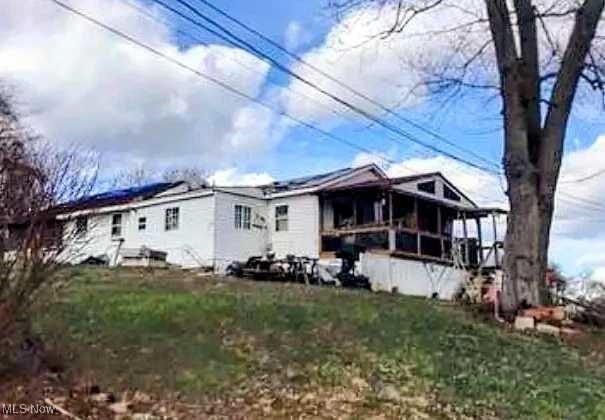 73 Comer St, Parkersburg, WV 26101 - view of front of home featuring a sunroom and a front yard