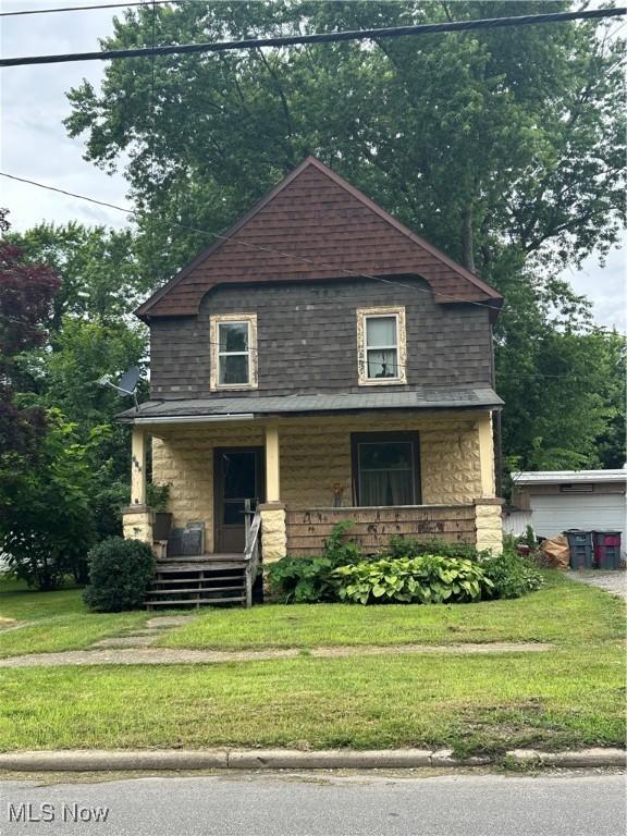 615 W 58th St, Ashtabula, OH 44004 - american foursquare style home with a porch, a front lawn, and stone siding