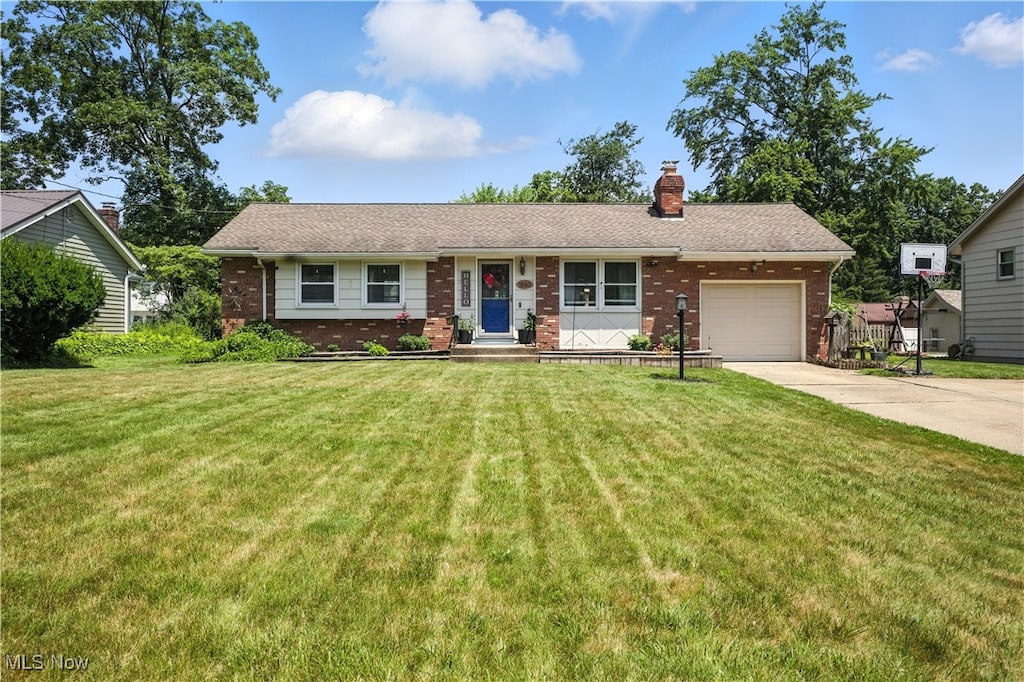 1860 Lancaster Dr, Youngstown, OH 44511 - ranch-style home with brick siding, a garage, a chimney, and a front lawn
