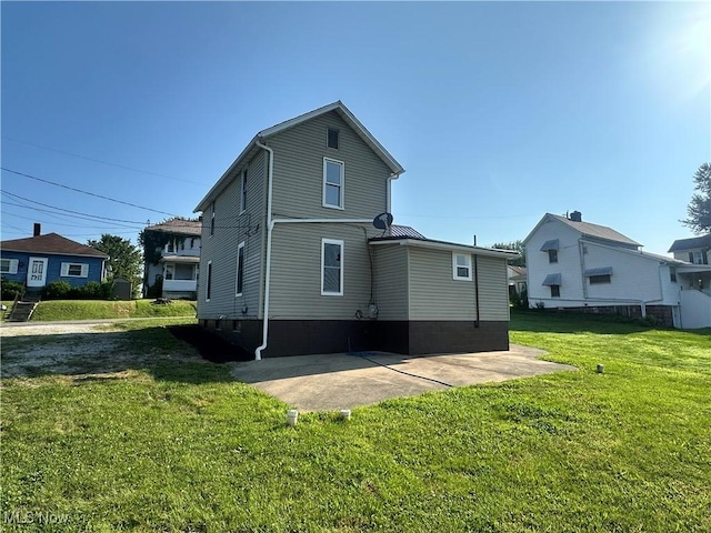 16707 Terrace Ave, Caldwell, OH 43724 - back of property featuring a lawn, a patio area, and a metal roof