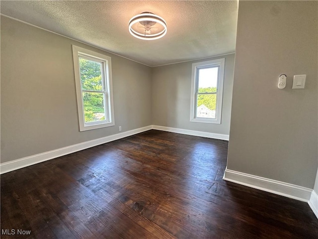 16707 Terrace Ave, Caldwell, OH 43724 - unfurnished room with healthy amount of natural light, dark wood-style flooring, and a textured ceiling