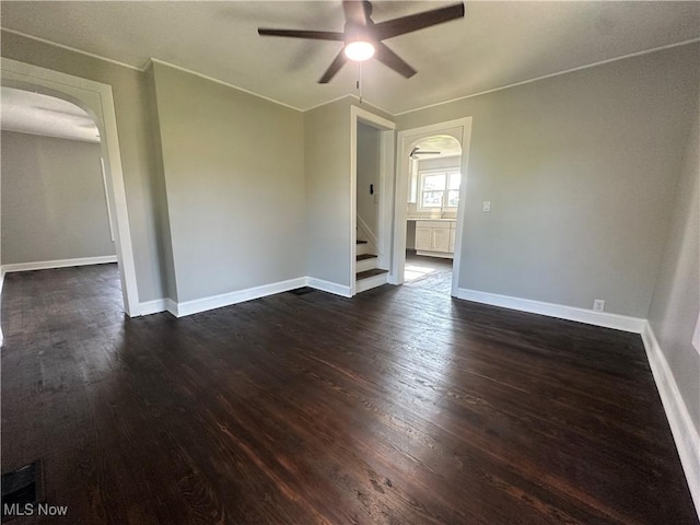16707 Terrace Ave, Caldwell, OH 43724 - empty room featuring arched walkways, a ceiling fan, dark wood-style floors, and ornamental molding