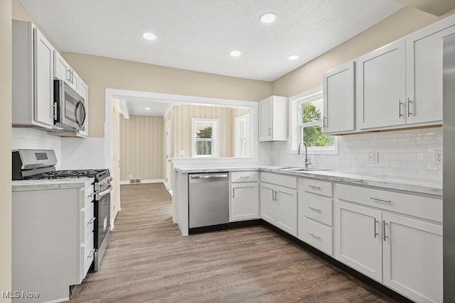 6434 Union Ave NE, Alliance, OH 44601 - kitchen featuring appliances with stainless steel finishes, light countertops, dark wood-style floors, decorative backsplash, and recessed lighting