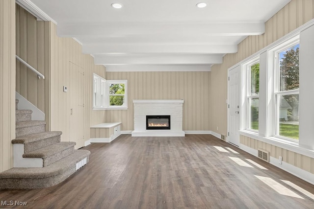 6434 Union Ave NE, Alliance, OH 44601 - unfurnished living room featuring beamed ceiling, wood finished floors, a glass covered fireplace, stairway, and recessed lighting