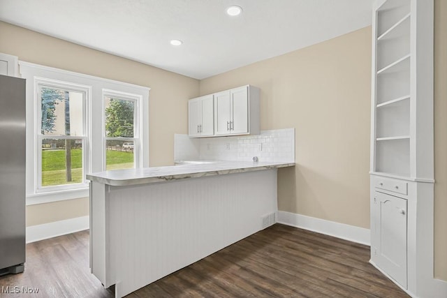6434 Union Ave NE, Alliance, OH 44601 - kitchen featuring stainless steel refrigerator, a peninsula, dark wood-type flooring, decorative backsplash, and white cabinetry