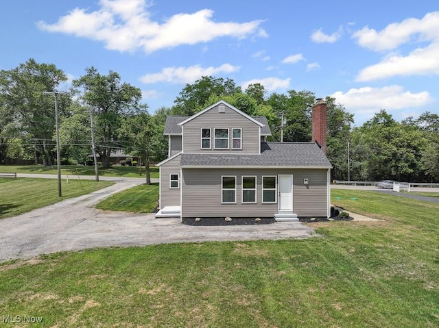 6434 Union Ave NE, Alliance, OH 44601 - back of house featuring entry steps, a chimney, a lawn, and roof with shingles