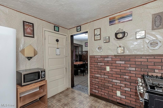 1744 Northfield Ave, East Cleveland, OH 44112 - kitchen with stainless steel appliances, ornamental molding, a textured ceiling, and tile patterned floors