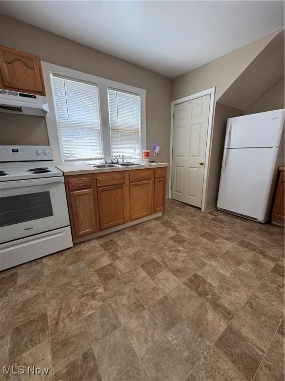 2239 23rd St SW, Akron, OH 44314 - kitchen with white appliances, under cabinet range hood, brown cabinets, and light countertops