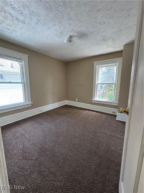 2239 23rd St SW, Akron, OH 44314 - empty room with a textured ceiling and dark carpet