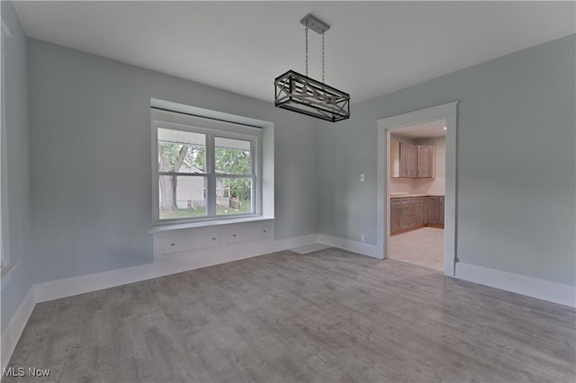 533 12th St, Campbell, OH 44405 - unfurnished dining area featuring wood finished floors and a chandelier
