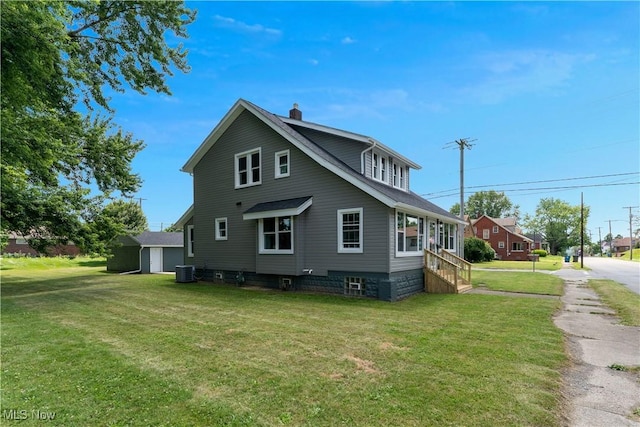 533 12th St, Campbell, OH 44405 - view of home's exterior with a chimney, a lawn, and a storage shed