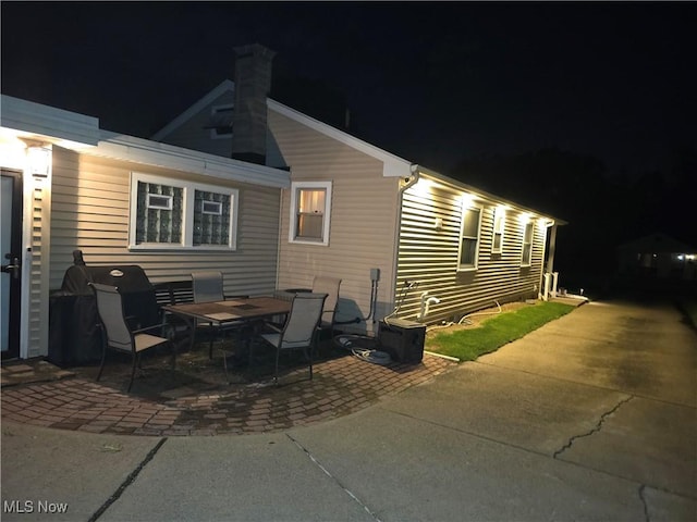 72 S Hartford Ave, Youngstown, OH 44509 - back of house at twilight with a patio area and a chimney