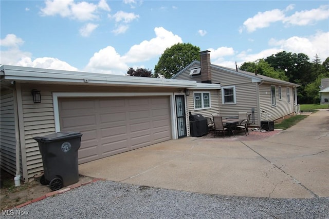 72 S Hartford Ave, Youngstown, OH 44509 - view of side of home featuring driveway, a chimney, and an attached garage