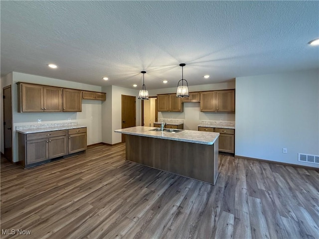 700 Whitetail Crossings, Wooster, OH 44691 - kitchen with dark wood finished floors, recessed lighting, an island with sink, decorative light fixtures, and a textured ceiling