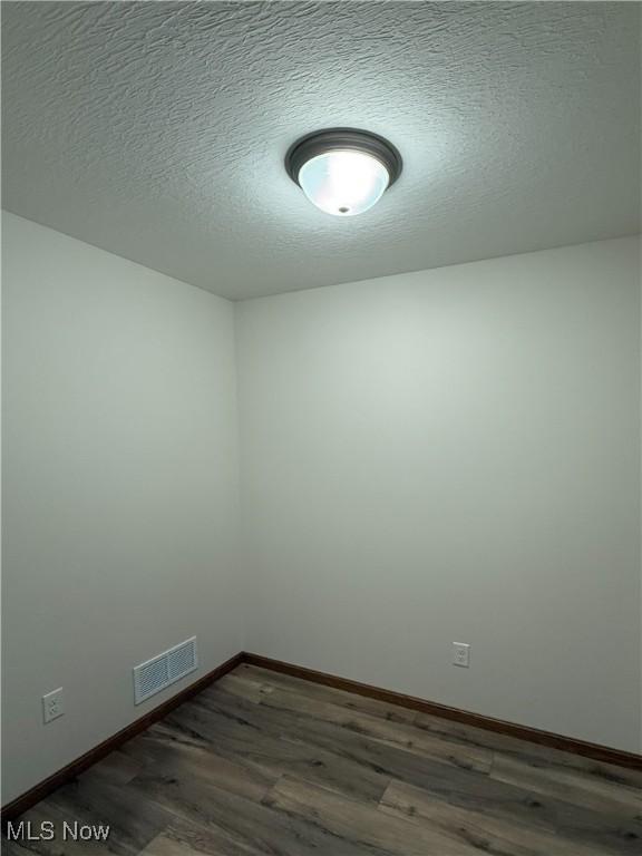 700 Whitetail Crossings, Wooster, OH 44691 - unfurnished room featuring dark wood-style floors and a textured ceiling