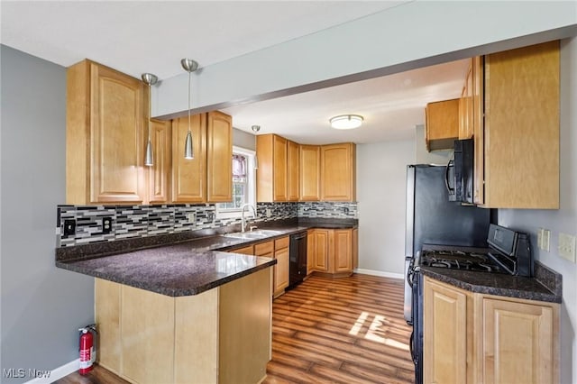 1811 Stepney St, Niles, OH 44446 - kitchen featuring black appliances, wood finished floors, tasteful backsplash, a peninsula, and decorative light fixtures