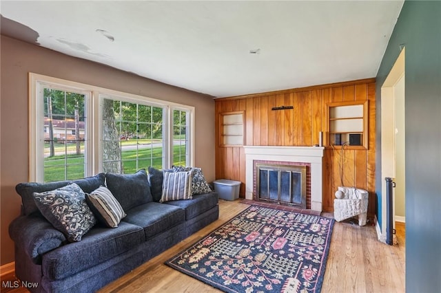 2992 Eldora Dr, Youngstown, OH 44511 - living room with a brick fireplace, light wood finished floors, and wood walls