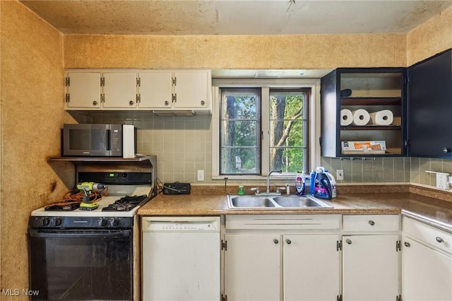 2992 Eldora Dr, Youngstown, OH 44511 - kitchen with range with gas cooktop, white dishwasher, stainless steel microwave, white cabinetry, and decorative backsplash