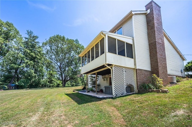 24 Heather Cir, Washington, WV 26181 - rear view of house with a chimney, a sunroom, a lawn, and a patio area