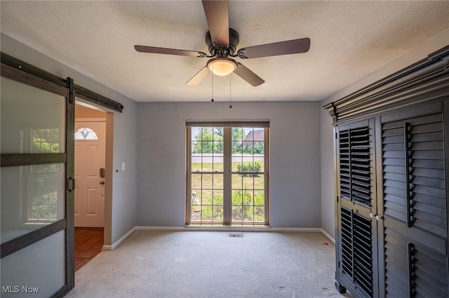 24 Heather Cir, Washington, WV 26181 - carpeted empty room featuring ceiling fan, a barn door, and a textured ceiling