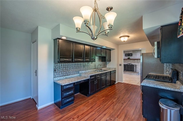 24 Heather Cir, Washington, WV 26181 - kitchen featuring a fireplace, black dishwasher, stainless steel microwave, decorative backsplash, and a chandelier