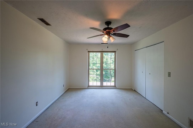 24 Heather Cir, Washington, WV 26181 - unfurnished bedroom featuring light colored carpet, a textured ceiling, a closet, and a ceiling fan