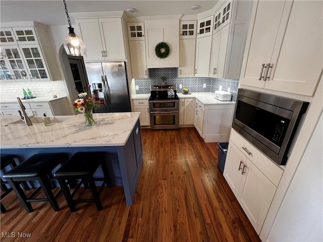 660 Rustic Knoll Dr, Kent, OH 44240 - kitchen with stainless steel appliances, dark wood-style floors, tasteful backsplash, and decorative light fixtures