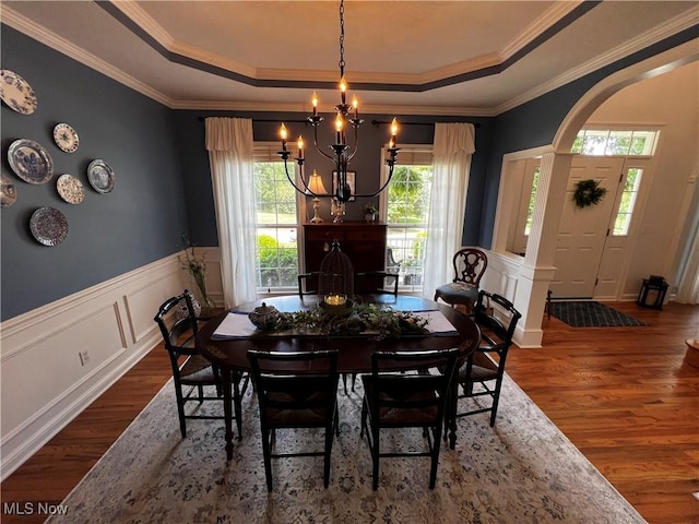 660 Rustic Knoll Dr, Kent, OH 44240 - dining space featuring a tray ceiling, a chandelier, dark wood-style flooring, crown molding, and a wainscoted wall