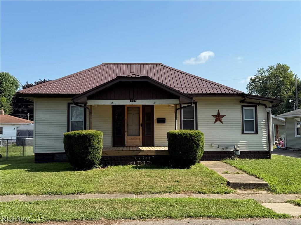 204 E 4th St, West Lafayette, OH 43845 - bungalow-style house featuring a porch and a metal roof