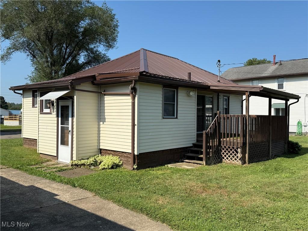 204 E 4th St, West Lafayette, OH 43845 - back of house with a lawn and a metal roof
