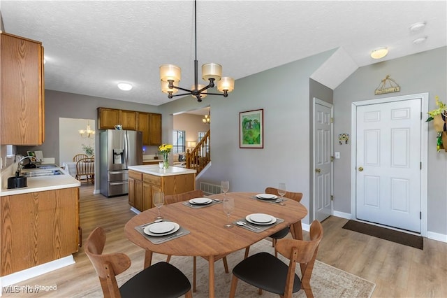 1648 E Turkey Run Dr, Newark, OH 43055 - dining area featuring a chandelier, light wood-type flooring, stairway, and a textured ceiling
