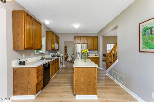 1648 E Turkey Run Dr, Newark, OH 43055 - kitchen featuring white appliances, light countertops, brown cabinetry, a kitchen island, and a textured ceiling