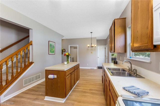 1648 E Turkey Run Dr, Newark, OH 43055 - kitchen featuring brown cabinetry, light countertops, light wood finished floors, and a textured ceiling