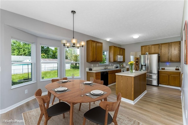 1648 E Turkey Run Dr, Newark, OH 43055 - kitchen with white appliances, brown cabinetry, light wood-style flooring, and a textured ceiling