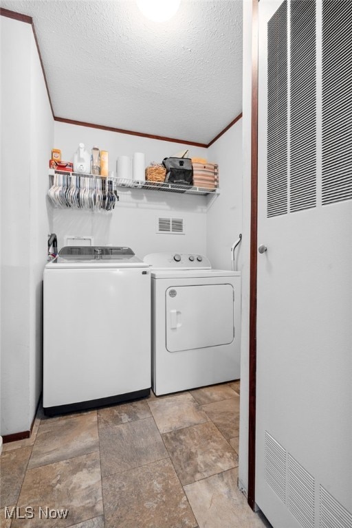 1467 Notman Rd, Deerfield, OH 44411 - laundry room with a heating unit, washer and clothes dryer, light stone finish flooring, a textured ceiling, and ornamental molding