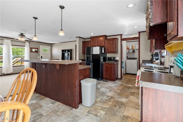 1467 Notman Rd, Deerfield, OH 44411 - kitchen featuring black fridge, washer / dryer, stainless steel microwave, a kitchen island, and a kitchen breakfast bar