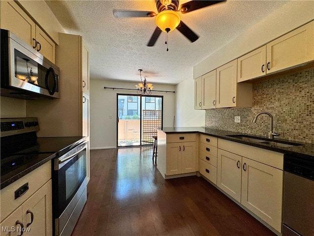 35049 N Turtle Trl Unit C, Willoughby, OH 44094 - kitchen with stainless steel appliances, a textured ceiling, a peninsula, dark wood-type flooring, and decorative backsplash