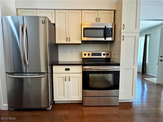 35049 N Turtle Trl Unit C, Willoughby, OH 44094 - kitchen with appliances with stainless steel finishes, dark countertops, dark wood-type flooring, and white cabinetry