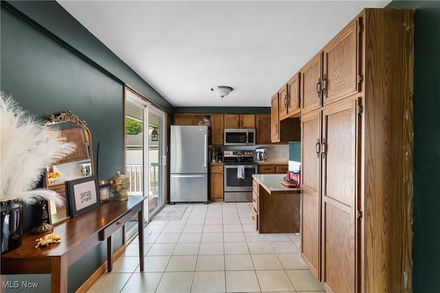 115 Coulter St, Creston, OH 44217 - kitchen with stainless steel appliances, light tile patterned floors, and brown cabinetry