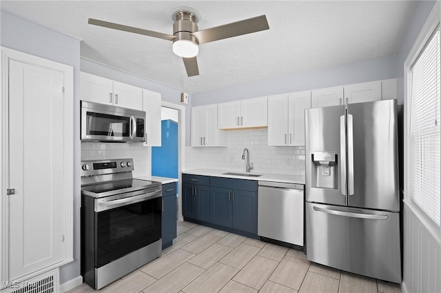 1835 Rockefeller Rd, Wickliffe, OH 44092 - kitchen featuring stainless steel appliances, white cabinets, light countertops, and tasteful backsplash