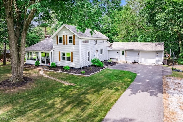 6170 Oberlin Rd, Amherst, OH 44001 - view of front of house with asphalt driveway, an attached garage, a front lawn, a shingled roof, and a sunroom